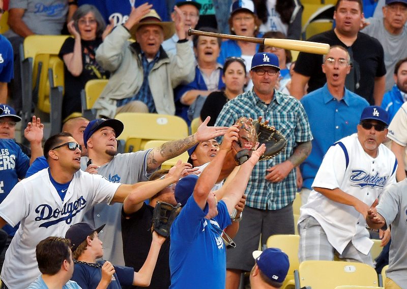 Fans try to catch a bat that Los Angeles Dodgers’ Howie Kendrick lost while at bat during the seventh inning of a baseball game against the St. Louis Cardinals, Sunday, June 7, 2015, in Los Angeles.