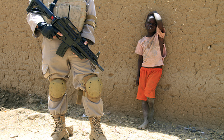 FILE: A young boy watches a United Nations peacekeeper in the North Darfur state capital of El-Fasher, on June 17, 2013. 