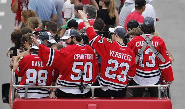 Chicago Blackhawks\’ Patrick Kane (88), Corey Crawford (50), Kris Versteeg (23) and Daniel Carcillo, ride in a parade celebrating the NHL hockey club\’s Stanley Cup championship, Thursday, June 18, 2015, in Chicago. (AP Photo/Charles Rex Arbogast)