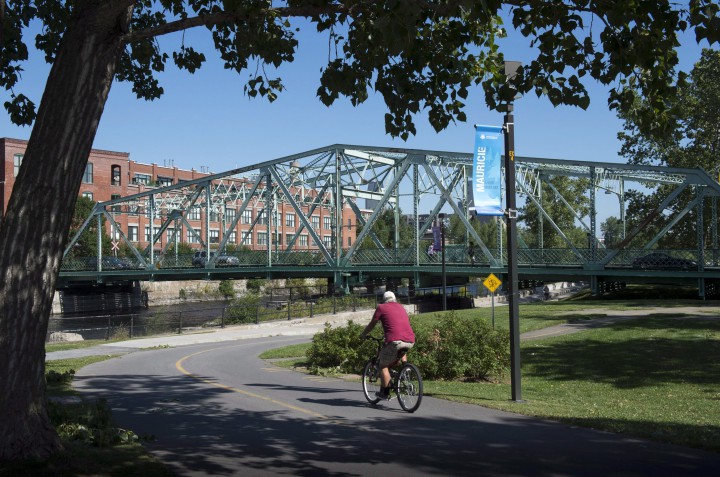A cyclist ride his bike along the Lachine Canal in Montreal.