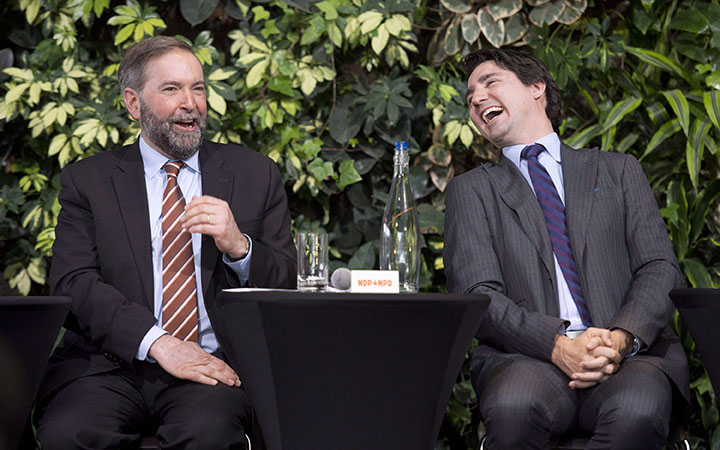 Liberal Leader Justin Trudeau laughs with NDP Leader Tom Mulcair as he speaks during a panel discussion on youth voting, Wednesday, March 26, 2014 in Ottawa.