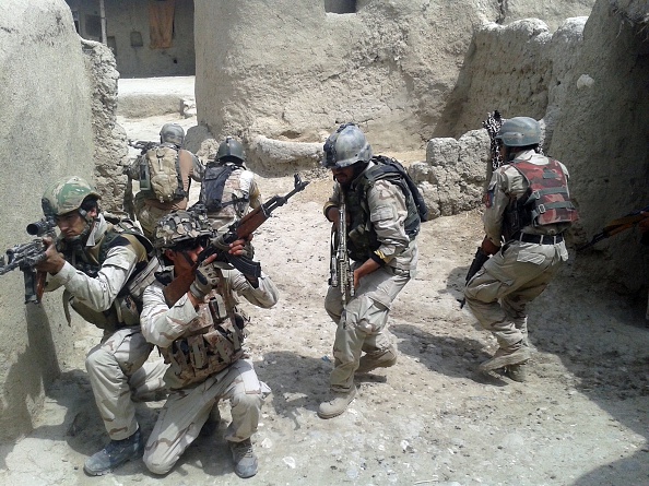 Afghan security forces patrol around the house after they fight against Taliban militants in Almar and Kaysar district of Faryab Province, Afghanistan, on July 22, 2015. At least 14 Taliban militant were killed by Afghan security forces during the clashes. (Photo by Mohammad Hassan Abdullah/Anadolu Agency/Getty Images).