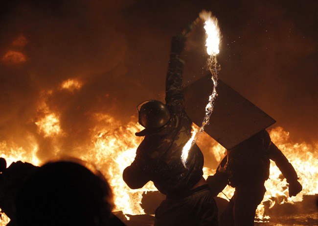 A protester throws a Molotov cocktail during clashes with police in central Kyiv, Ukraine, early Saturday, Jan. 25, 2014.
