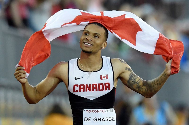 Andre De Grasse, of Canada, hold a flag after he wins the gold medal in the men’s 100m final during the athletics competition at the 2015 Pan Am Games in Toronto on Wednesday, July 22, 2015.