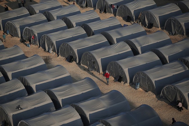 FILE - In this Oct, 17, 2014, file photo, Syrian Kurdish refugees who fled fighting in Kobani, Syria, go about at a refugee camp in Suruc, on the Turkey-Syria border.