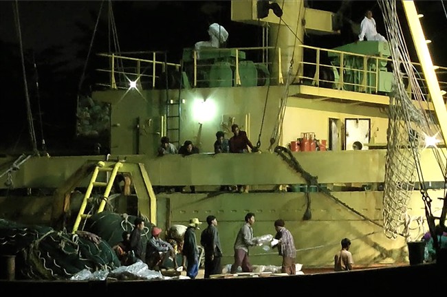 FILE – In this Thursday, Nov. 27, 2014 image from video, workers from Myanmar load fish onto a Thai-flagged cargo ship in Benjina, Indonesia. An intricate web of connections separates the fish we eat from the men who catch it, and obscures a brutal truth: Your seafood may come from slaves.