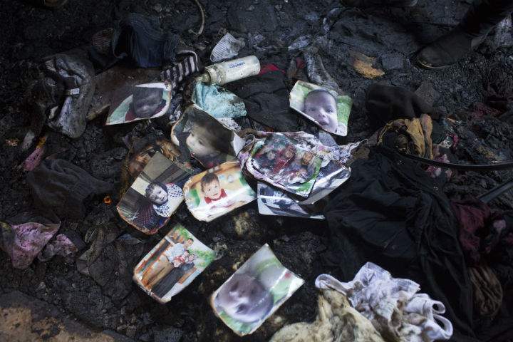 Family members and relatives of 18-month-old baby, Ali Dawabsha, view the remains of their house after a fire which was suspected to have been set by Jewish extremists. in the Palestinian village of Duma, West Bank.