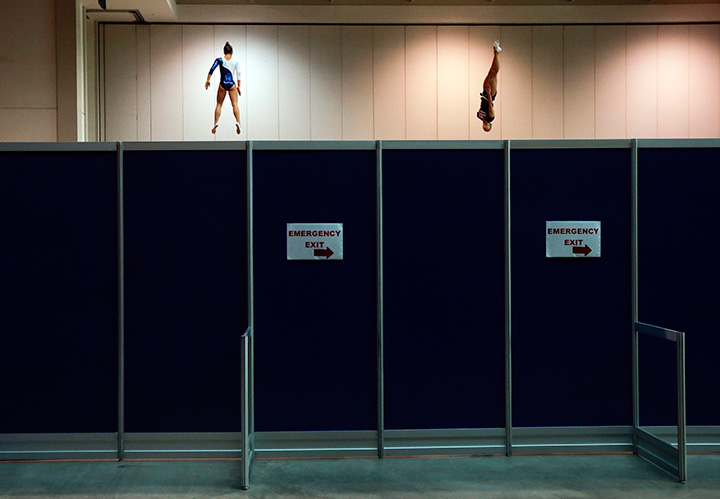 Brazil’s Camilla Lopes, left, and the United States’ Charlotte Drury warm up on trampolines behind a partition before women’s trampoline competition at the Pan Am Games in Toronto, Sunday, July 19, 2015.
