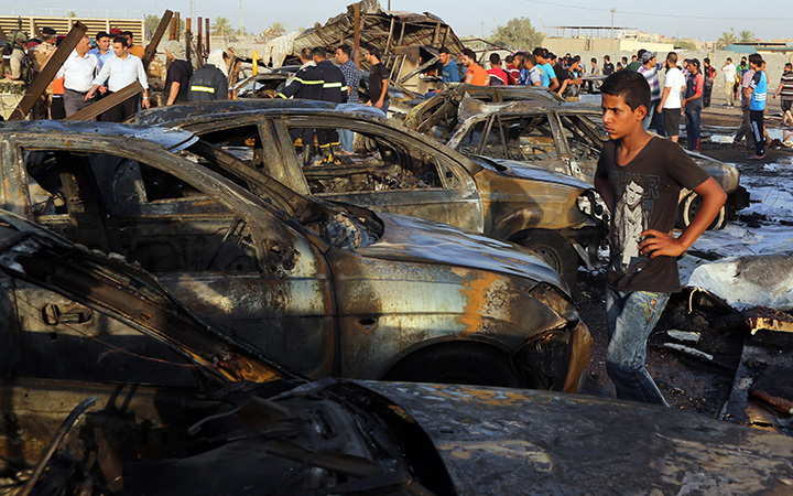 Civilians gather at the scene of a deadly car bomb in the Habibiya neighborhood of Sadr City, Baghdad, Iraq, Saturday, Aug. 15, 2015.