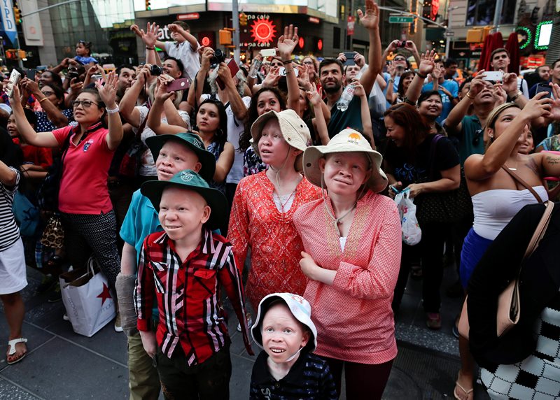 Emmanuel Rutema, Kabula Masanja, Pendo Noni, Mwigulu Magesa and Baraka Lusambo watch the Revlon live camera with a crowd of other tourists during a visit to Times Square in New York on Tuesday, July 28, 2015.