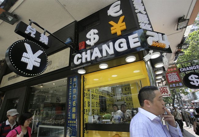 A man walks past a currency exchange shop in Hong Kong, Tuesday, Aug. 11, 2015. China devalued its tightly controlled currency Tuesday following a slump in trade, allowing the yuan\’s biggest one-day decline in a decade.