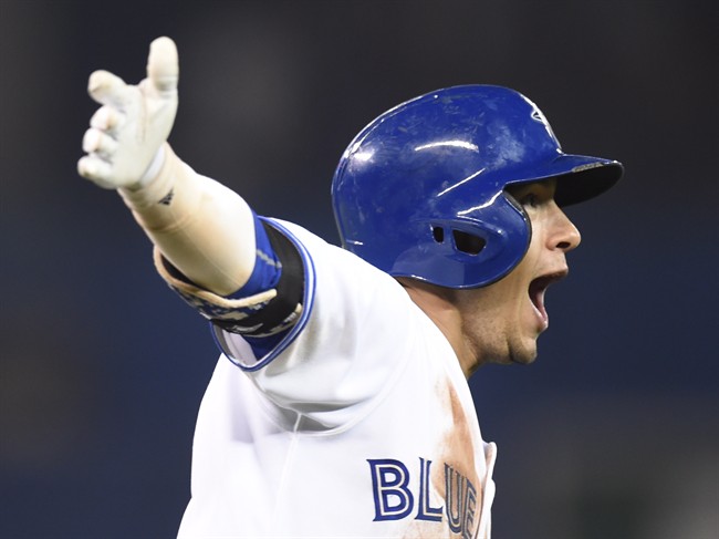 Toronto Blue Jays' Ryan Goins celebrates his walk off home run against the Cleveland Indians as he rounds first base during tenth inning American League baseball action in Toronto on Tuesday, Sept.1, 2015.