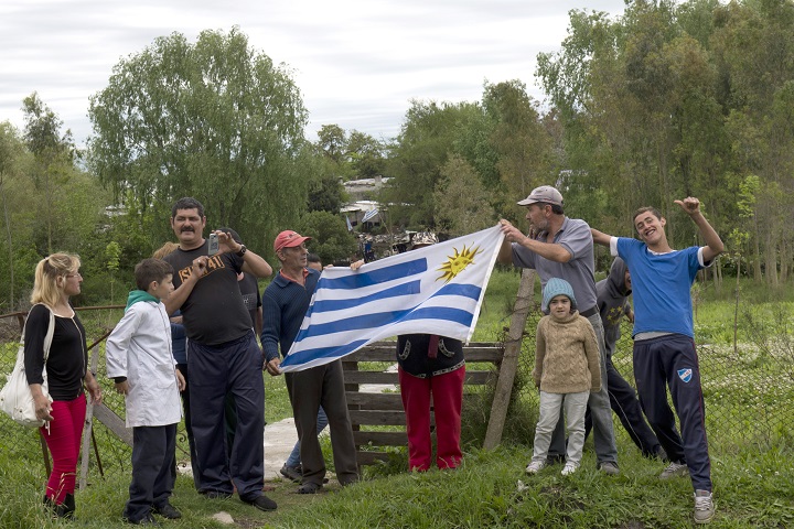 Neighbors gather to welcome the Syrian refugees as they arrive at their temporary accomodation in Montevideo on October 9, 2014. After a two-day journey and more than 12,000 km, 42 Syrian refugees, mostly children, arrived in Uruguay on the first stage of an unprecedented plan of resettlement in the region promoted by Uruguay's President Jose Mujica.