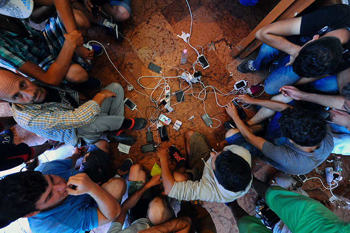 Migrants charge their mobile phones at the Eastern (Keleti) railway station in Budapest on August 31, 2015.