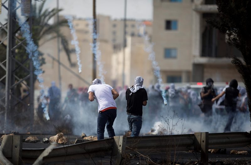 Tear gas rain down on Palestinians during clashes with Israeli troops near Ramallah, West Bank, Saturday, Oct. 10, 2015. Palestinians carried out two stabbing attacks in Jerusalem on Saturday before being shot dead by police, while another two Palestinians were killed during a violent demonstration near the Gaza border fence, the latest in a series of stabbing attacks against civilians and soldiers that have spread across Israel and the West Bank in the past week