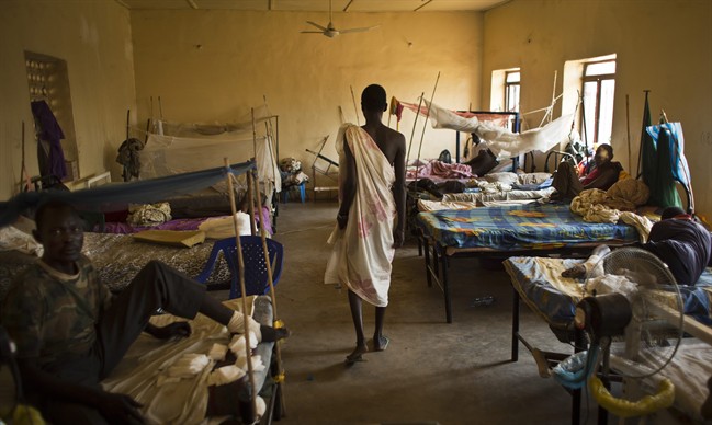 In this Saturday, Dec. 28, 2013 file photo, a man with gunshot wounds walks in a ward inside the Juba Military Hospital in Juba, South Sudan. 