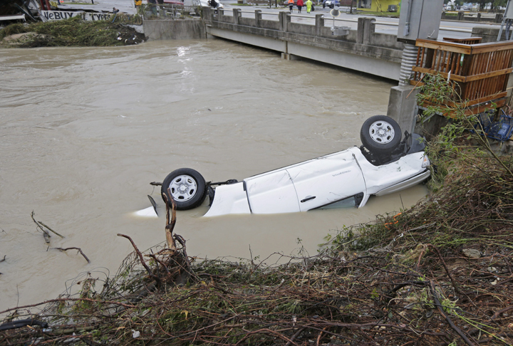 A pickup truck rests against the side of Gills Creek near a bridge in Columbia, S.C., Monday, Oct. 5, 2015.