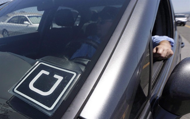 An Uber driver sits in his car parked near the San Francisco International Airport parking area in San Francisco, Wednesday, July 15, 2015.