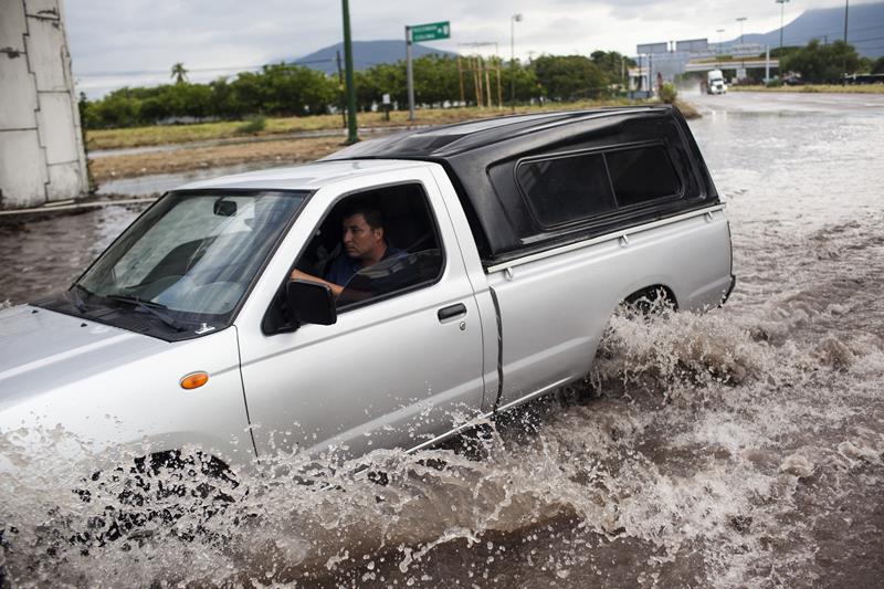 A truck drives through a flooded out turn off at the entrance to the city after heavy flooding from Hurriane Patricia October 24, 2015 in Tecoman, Colima, Mexico.