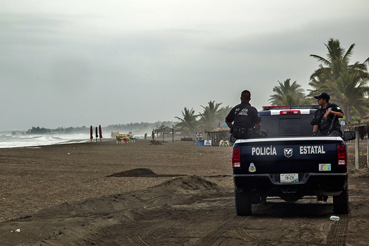 Police patrol the beach in Boca de Pascuales, Colima State, Mexico, on October 22, 2015. Fast-moving Patricia grew into an “extremely dangerous” major hurricane off Mexico’s Pacific coast on Thursday, forecasters said.