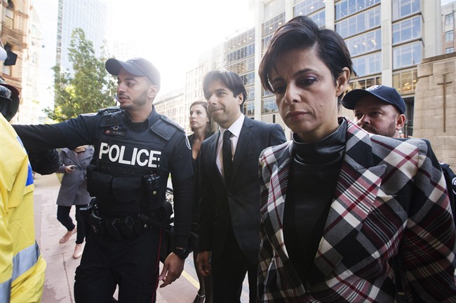 Police escort former CBC radio host Jian Ghomeshi, centre, who appears with his lawyer Marie Henein, right, for his pre-trial hearing for his sexual assault case in Toronto on Thursday, October 1, 2015. 