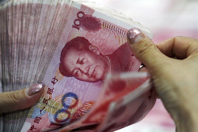 In this Tuesday, Aug. 11, 2015 photo, a bank clerk counts Chinese currency notes at a bank outlet in Huaibei in central China's Anhui province. Donald Trump has threatened to name China as a currency manipulator.