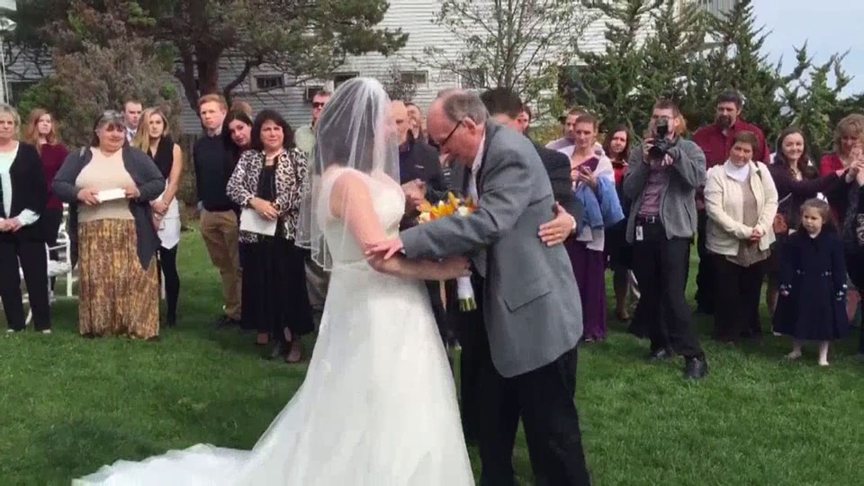 Wheelchair-bound father surprises daughter, walks her down aisle - image