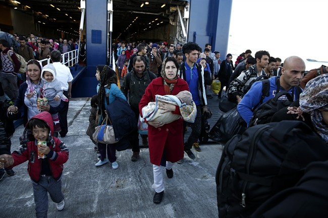 Migrants and refugees disembark from a ferry after their arrival from the northeastern Greek islands of Lesbos and Chios at the Athens' port of Piraeus, Sunday Oct. 25, 2015.