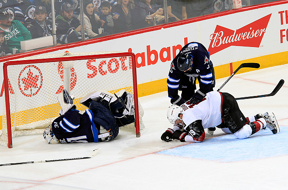 Winnipeg Jets goalie Ondrej Pavelec lays in the net after being run into by Shane Doan of the Arizona Coyotes during the second at MTS Centre.