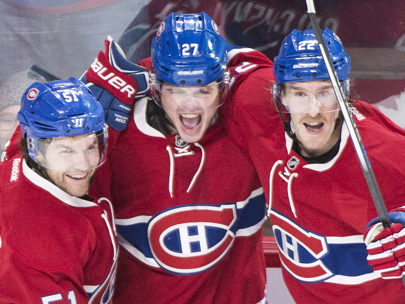 Montreal Canadiens' Alex Galchenyuk (27) celebrates with teammates David Desharnais (51) and Dale Weise after scoring against the New York Islanders during third period NHL hockey action in Montreal Sunday, November 22, 2015.