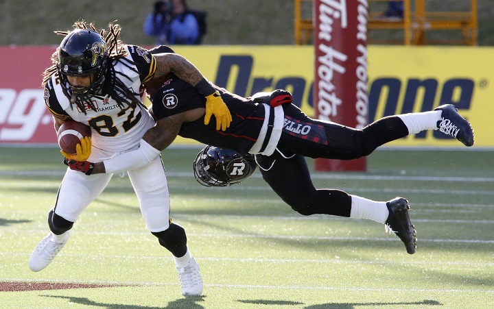 The Ottawa Redblacks Jovon Johnson tackles the Hamilton Tiger-Cats Kealoha Pilares during first quarter eastern final CFL action in Ottawa on Saturday, November 22, 2015.  (CFL PHOTO - Patrick Doyle).