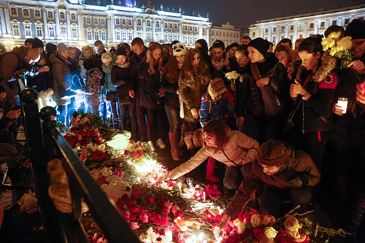 People light candles during a day of national mourning for the plane crash victims at Dvortsovaya (Palace) Square in St. Petersburg, Russia, on Sunday, Nov. 1, 2015.