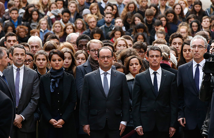 French President Francois Hollande (centre), flanked by French Prime Minister Manuel Valls (second right) and French Education Minister Najat Vallaud-Belkacem, (second left) stand among students during a minute of silence in the courtyard of the Sorbonne University in Paris, Monday, Nov. 16 2015.