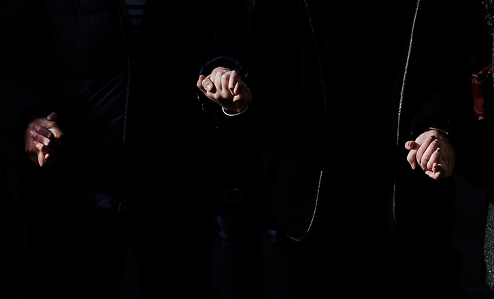 People hold hands as they observe a minute of silence in Lyon, central France, Monday, Nov. 16, 2015, three days after the Paris attacks.