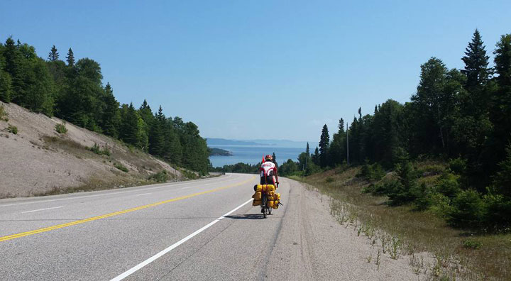 This photo shows Rob Howse biking in July 2015 near Lake Superior.