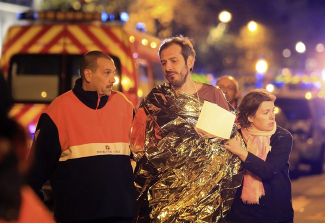 A man is being evacuated from the Bataclan theater after a shooting in Paris, Friday Nov. 13, 2015. French President Francois Hollande declared a state of emergency and announced that he was closing the country’s borders.