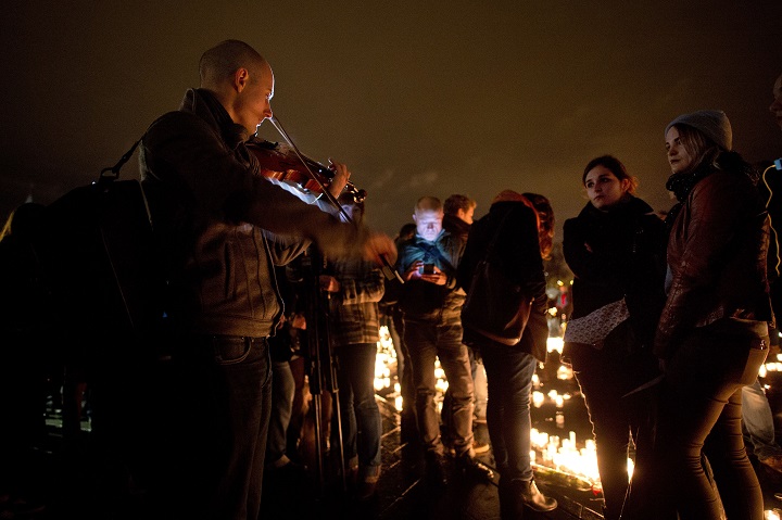 A man plays violin on November 20, 2015 during a gathering on the water mirror on the esplanade of the Chateau des Ducs in Nantes, western France, to pay tribute to the victims of the attacks of November 13.