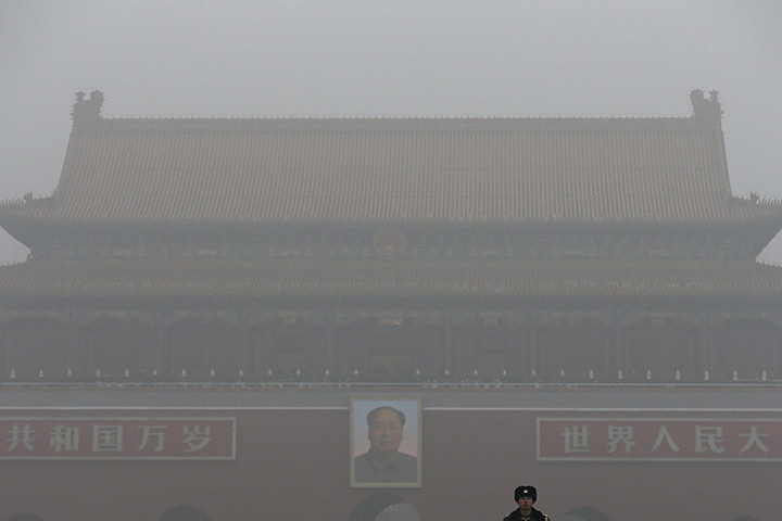 A Chinese paramilitary policeman stands on duty near Tiananmen Gate shrouded with heavy pollution and fog in Beijing, Tuesday, Dec. 1, 2015.