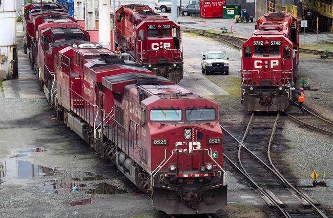 A Canadian Pacific Rail maintenance worker climbs onto a locomotive at the company's Port Coquitlam yard east of Vancouver, B.C., on Wednesday May 23, 2012. 