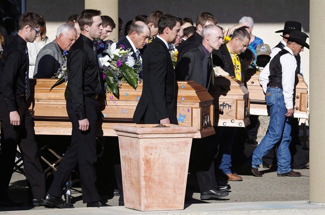 Pall bearers carry the three coffins of Catie Bott, who was 13, and her twin 11-year-old siblings, Jana and Dara Bott in Red Deer, Alta., Friday, Oct. 23, 2015.