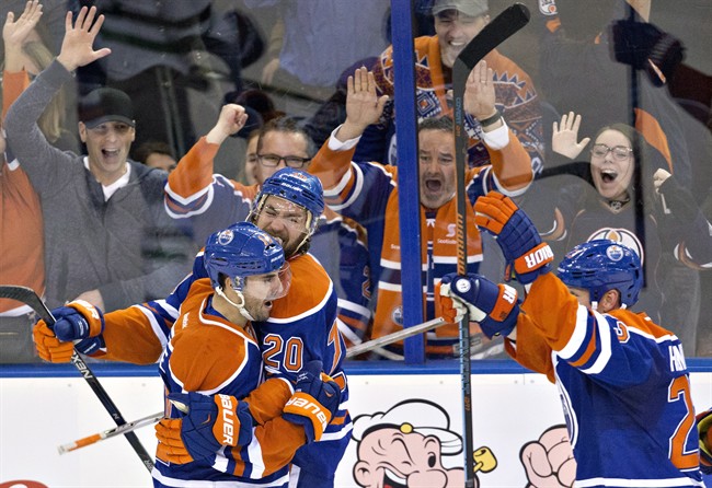 Edmonton Oilers' Jordan Eberle (14), Luke Gazdic (20) and Matt Hendricks (23) celebrate Eberle's goal against the Dallas Stars during overtime NHL action in Edmonton, Alta., on Friday December 4, 2015.