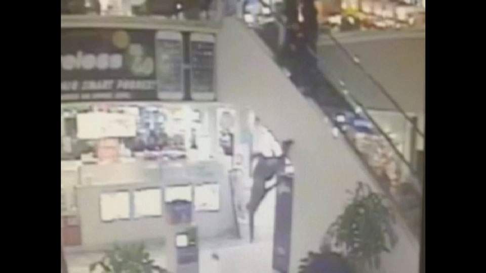Caught on camera: man jumps over side of escalator while trying to flee police - image