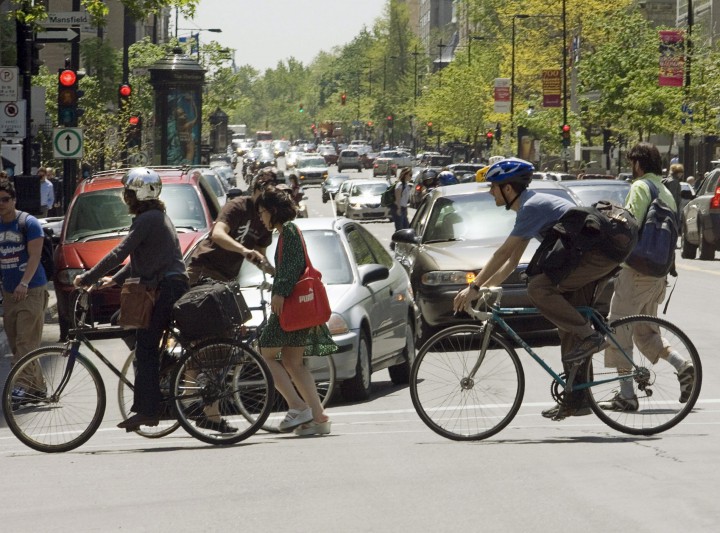 Pedestrians and cyclists cross Sherbrooke Street in downtown Montreal.