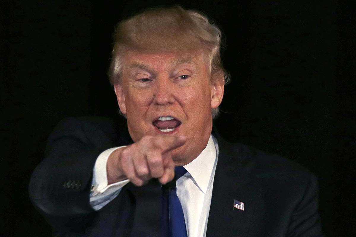 In this Dec. 10, 2015, photo, Republican presidential candidate, businessman Donald Trump gestures during an address at a regional police union meeting in Portsmouth, N.H. T.