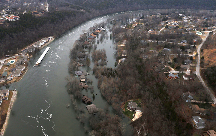 In this Tuesday, Dec. 29, 2015 photo, rising waters of Lake Taneycomo flood several homes in Branson, Mo.