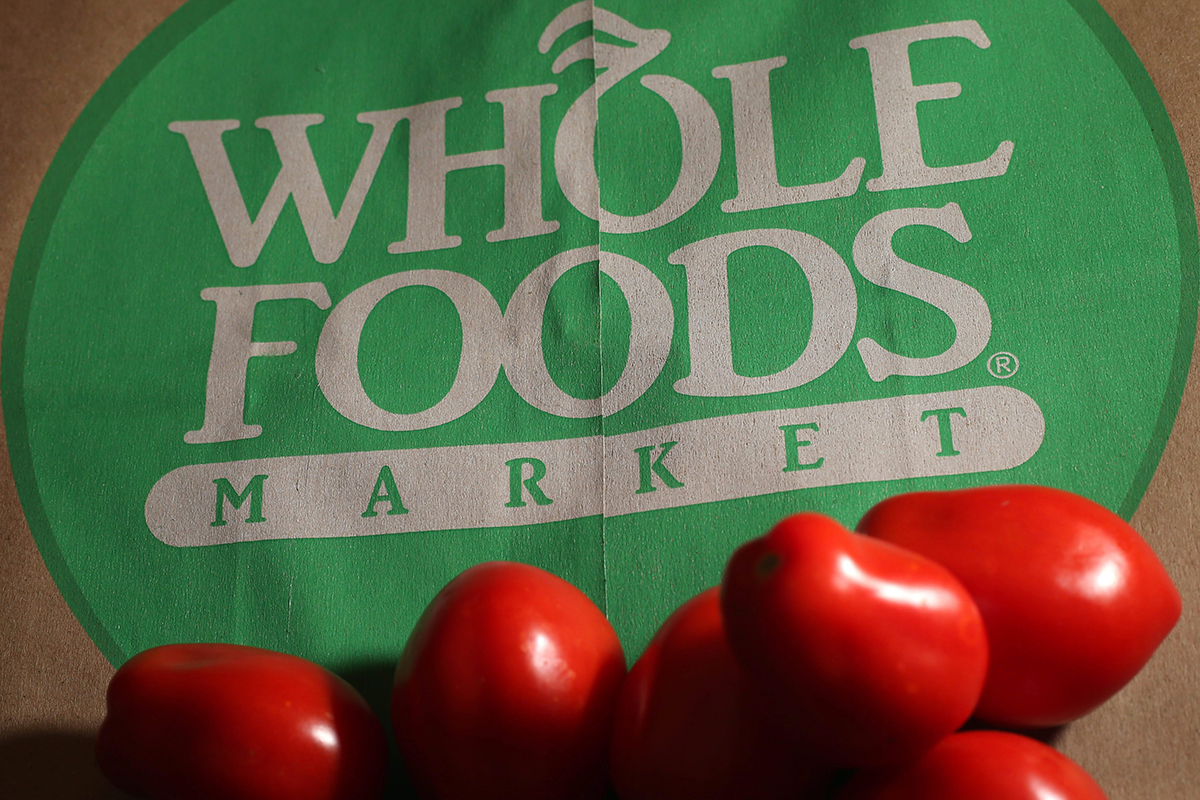 In this Monday, July 29, 2013, file photo, produce is placed on a Whole Foods paper bag in Andover, Mass. Grocery chain Whole Foods is cutting about 1,500 jobs, or 1.6 percent of its workforce, over the next eight weeks as it looks to lower prices and keep up with competition, the company announced Monday, Sept. 28, 2015.