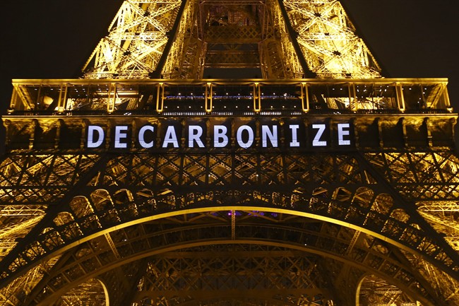 The slogan "DECARBONIZE" is projected on the Eiffel Tower as part of the COP21, United Nations Climate Change Conference in Paris, France, Friday, Dec. 11, 2015. 