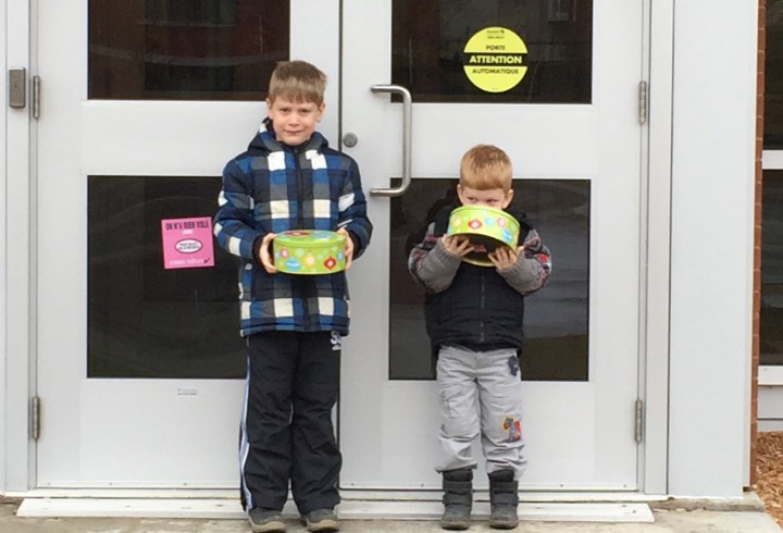 Kyle Mericx, 6 and Lucas Mericx, 3, stand outside their local police station with boxes of cookies.