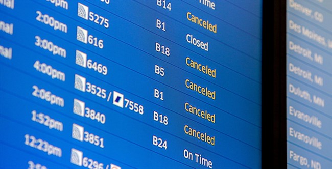 Flight boards at O'Hare International Airport show cancellations Friday, Jan. 22, 2016 in Chicago.