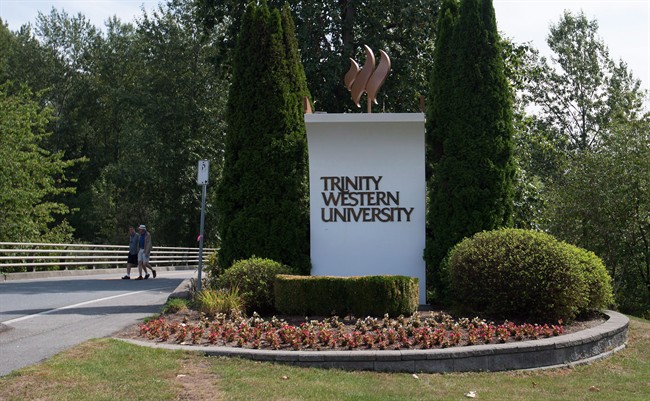 Two men walk past the entrance to Trinity Western University, in Langley, B.C., on August 24, 2015.